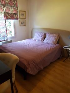 a bedroom with a bed with two pillows and a window at Appartement avec jardin in Eysines