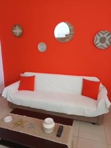 a living room with a white couch and a red wall at Endless Blue Apartments in Keratokampos