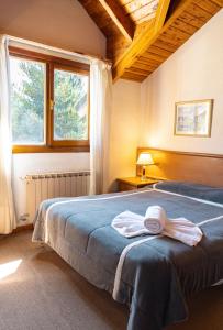 Un dormitorio con una cama con una toalla. en Loft Catedral by Base 41 en San Carlos de Bariloche