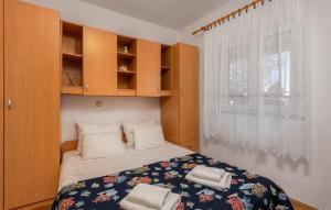 a small bedroom with a bed and a window at Apartment Sabina&Zoran in Malinska