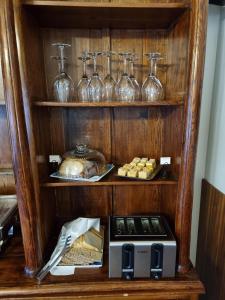a shelf with wine glasses and a plate of food at Hotel Skógá by EJ Hotels in Skogar