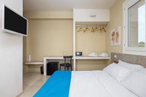 a bedroom with a bed and a desk and a television at Fiore di Vendicari B&B - Sicilian Charme, Lemon Grove and Sea in Noto