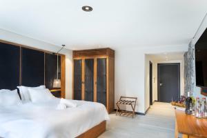 Un dormitorio con una gran cama blanca y una mesa en Yarden Estate Boutique Hotel, en Yesod Hamaala