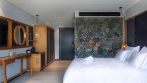 1 dormitorio con 1 cama grande y pared de piedra en Yarden Estate Boutique Hotel en Yesod Hamaala