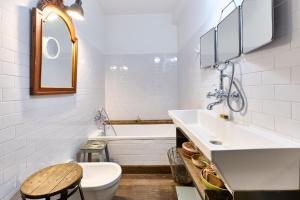 a bathroom with a sink and a tub and a toilet at Très beau Loft Industriel Paris 20e in Paris