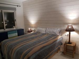 a bedroom with a large bed and two lamps at La Terrasse du Leo, Benicarló in Benicarló