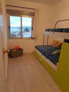 a bedroom with a bunk bed and a window at La Terrasse du Leo, Benicarló in Benicarló