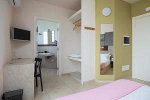 a bedroom with a bed and a sink and a mirror at Fiore di Vendicari B&B - Sicilian Charme, Lemon Grove and Sea in Noto
