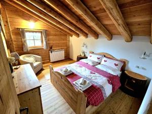a bedroom with a bed in a wooden house at Baita dei Fovi in Baselga di Pinè