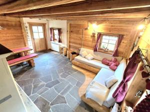 a living room with a couch in a wooden cabin at Baita dei Fovi in Baselga di Pinè