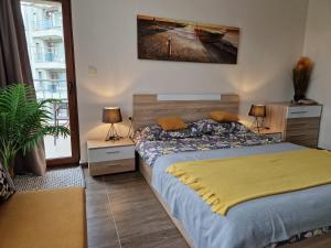 a bedroom with a bed with a yellow blanket on it at Sun Wave Apartament in Sveti Vlas +15 photos