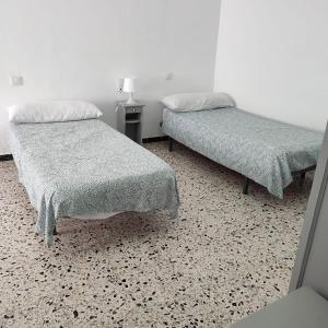 - une chambre avec deux lits et une table avec une lampe dans l'établissement Duplex en centro de Chipiona, à Chipiona