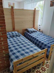 two beds sitting next to each other in a bedroom at Grand appartement indépendant, 4 personnes et plus, piscine et jardin in Toulouse