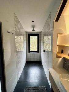 a bathroom with a walk in shower and a window at The Unbound - Escape the Ordinary in Romansrivier