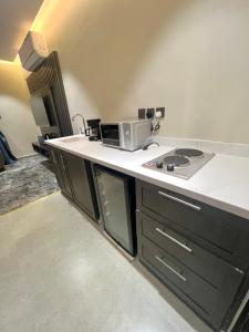 a kitchen with a counter top with a microwave at درة السلطان للشقق الفندقية in AlUla +21 photos