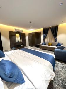 a large bedroom with a large bed and a couch at درة السلطان للشقق الفندقية in AlUla