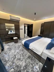 a bedroom with a large bed and a mirror at درة السلطان للشقق الفندقية in AlUla