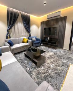 a living room with a couch and a tv at درة السلطان للشقق الفندقية in AlUla