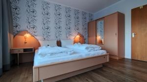 a bedroom with a large bed with white pillows at Ostseehotel Kappeln by team SchleiFee in Kappeln