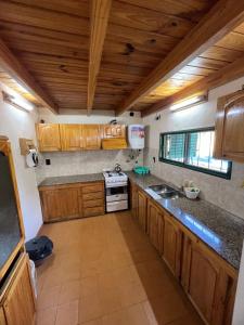 eine Küche mit Holzschränken und einem Herd mit Backofen in der Unterkunft Quinta Trento in Villa María + 3 Fotos