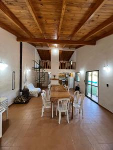 ein Wohnzimmer mit Holzdecke und einem Tisch und Stühlen in der Unterkunft Quinta Trento in Villa María