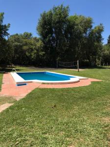 ein Pool in einem Garten mit einem Rasenplatz in der Unterkunft Quinta Trento in Villa María
