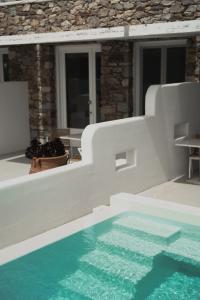 a swimming pool in front of a house at Mykonos Pantheon in Kalo Livadi