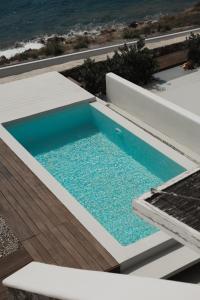a swimming pool with the ocean in the background at Mykonos Pantheon in Kalo Livadi