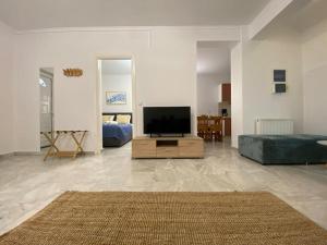 a living room with a flat screen tv on a wooden cabinet at Mermaid apartment Nafplio in Nafplio