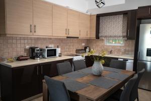 a kitchen with a wooden table with a vase on it at Τα ανετα διαμμερισματα του Λεκα Α2 in Zakharo