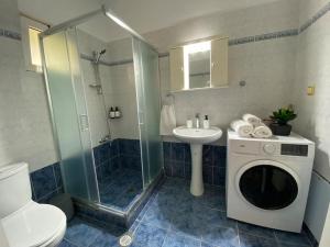 a bathroom with a sink and a washing machine at Mermaid apartment Nafplio in Nafplio +20 photos