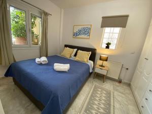a bedroom with a blue bed with towels on it at Mermaid apartment Nafplio in Nafplio