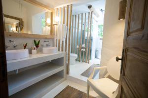 a bathroom with a sink and a toilet and a mirror at Santa Fe Casas- Quadrado Trancoso in Trancoso