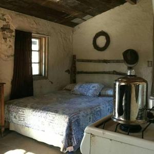 Un dormitorio con una cama y una licuadora sobre una estufa. en Rancho Callado - Cucapa Cabin, en Tijuana