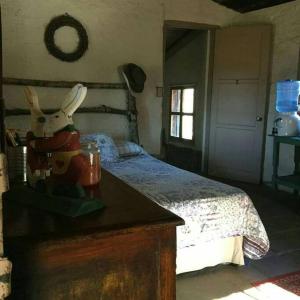 Un dormitorio con una cama y una mesa con un animal de peluche en Rancho Callado - Cucapa Cabin, en Tijuana