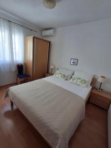 - une chambre avec un grand lit blanc et une chaise bleue dans l'établissement Apartment Irena Bol, à Bol