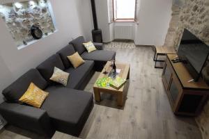 a living room with a black couch and a table at La Romarine in Chauzon