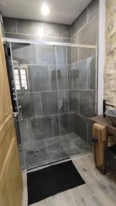 a bathroom with a shower with a tiled wall at La Romarine in Chauzon +27 photos