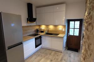a kitchen with white cabinets and a sink at La Romarine in Chauzon