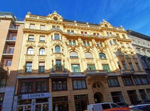 ブダペストにあるPalace Apartmentの市道の大きな黄色の建物