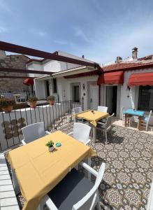 een patio met 2 tafels en stoelen en een hek bij Alaçatı Disa in Alacati