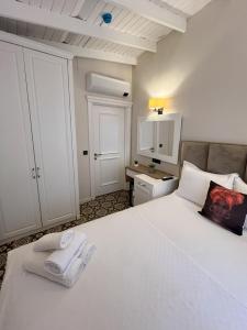 a bedroom with a large white bed with towels on it at Alaçatı Disa in Alacati