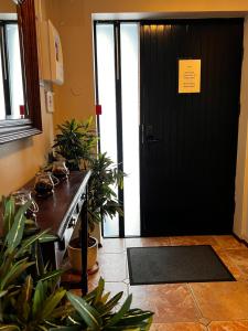 una porta nera con delle piante e un cartello sopra di Hotel Skógá by EJ Hotels a Skogar