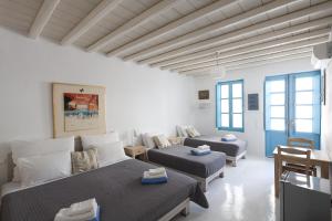 a white room with two beds and a couch at Mykonos Pantheon in Kalo Livadi