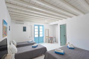 a room with two beds and a flat screen tv at Mykonos Pantheon in Kalo Livadi +37 photos