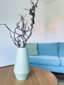 eine blaue Vase mit einer Pflanze auf dem Tisch in der Unterkunft Lay-Zeit in Kottenheim
