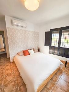 贝莱斯德韦瑙达利亚Pura Vida - Terraza, Piscina, Playa 15mn, Sierra的房间里有一张白色大床的卧室