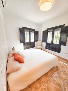 a large white bed in a room with windows at Pura Vida - Terraza, Piscina, Playa 15mn, Sierra in Vélez de Benaudalla +10 photos