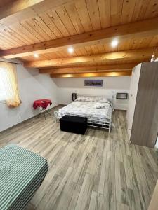 Debel house في مارينا دي راغوزا: غرفة نوم بسرير وسقف خشبي