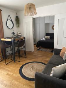 a living room with a table and a couch at Charmant 2 pièce 35m2 in Montrouge